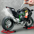 Realistic black toy motorcycle with green accents emitting smoke, on display at Tafeen Toys